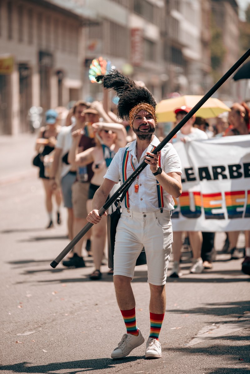 Teilnehmer mit Schild und T-Shirt mit politischer Botschaft l?ft in der Pride-Parade mit.