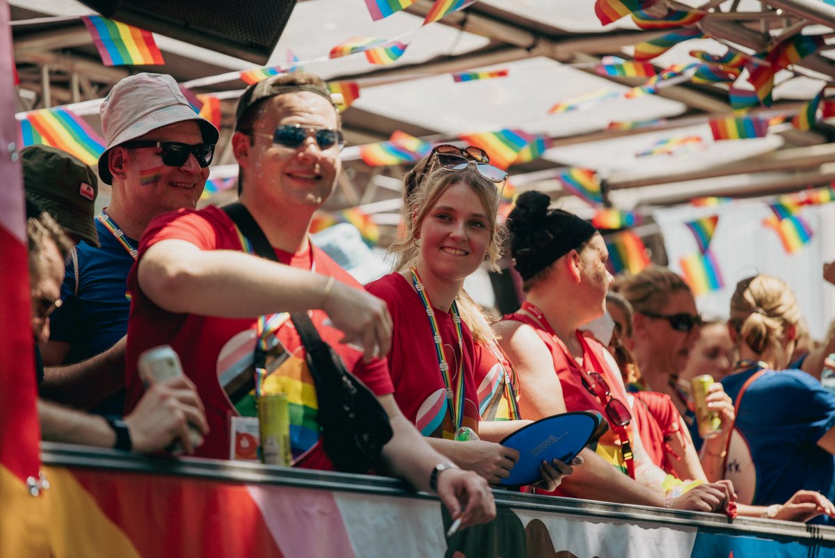 Teilnehmende auf einem bunt dekorierten Wagen gr?en die Menge entlang der Paradestrecke.
