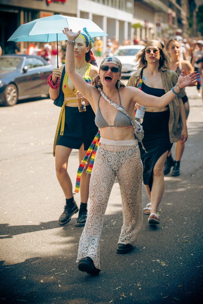 Zwei Teilnehmende in glitzernden Outfits laufen gemeinsam durch die sonnige Stra?.