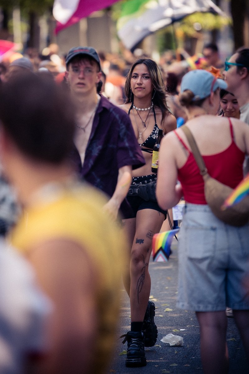 Menschenmenge bewegt sich durch die Pride-Parade, im Vordergrund stehen Teilnehmende im Gespr?h.