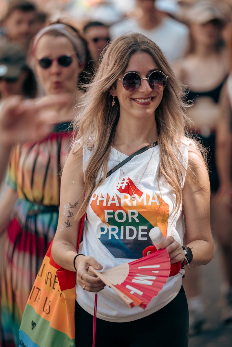 L?helnde Helferin oder Teilnehmerin tr?t ein rotes ?Munich for Pride?-Shirt und steht am Stra?nrand.