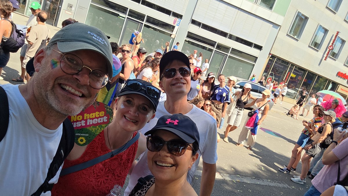 Drei Personen machen ein fr?liches Selfie am Rand der CSD-Parade.