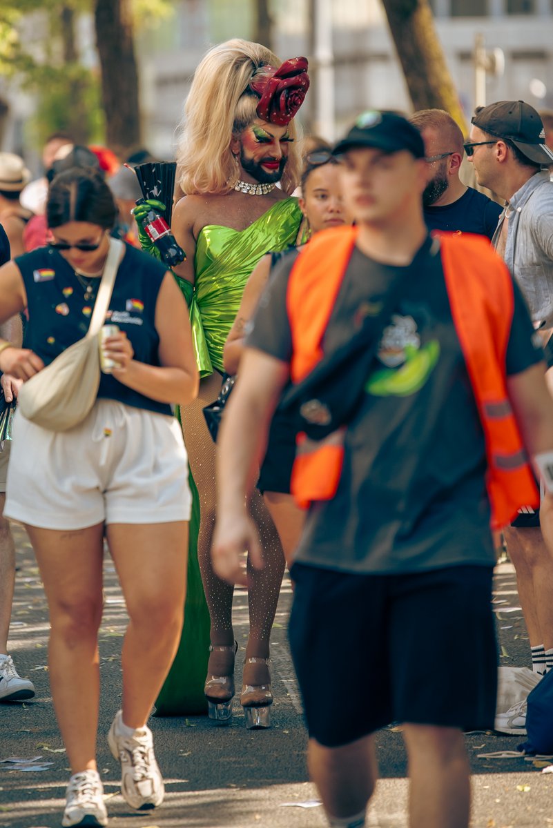 Zwei Teilnehmende posieren gemeinsam auf der Stra?, im Hintergrund l?ft die Parade weiter.