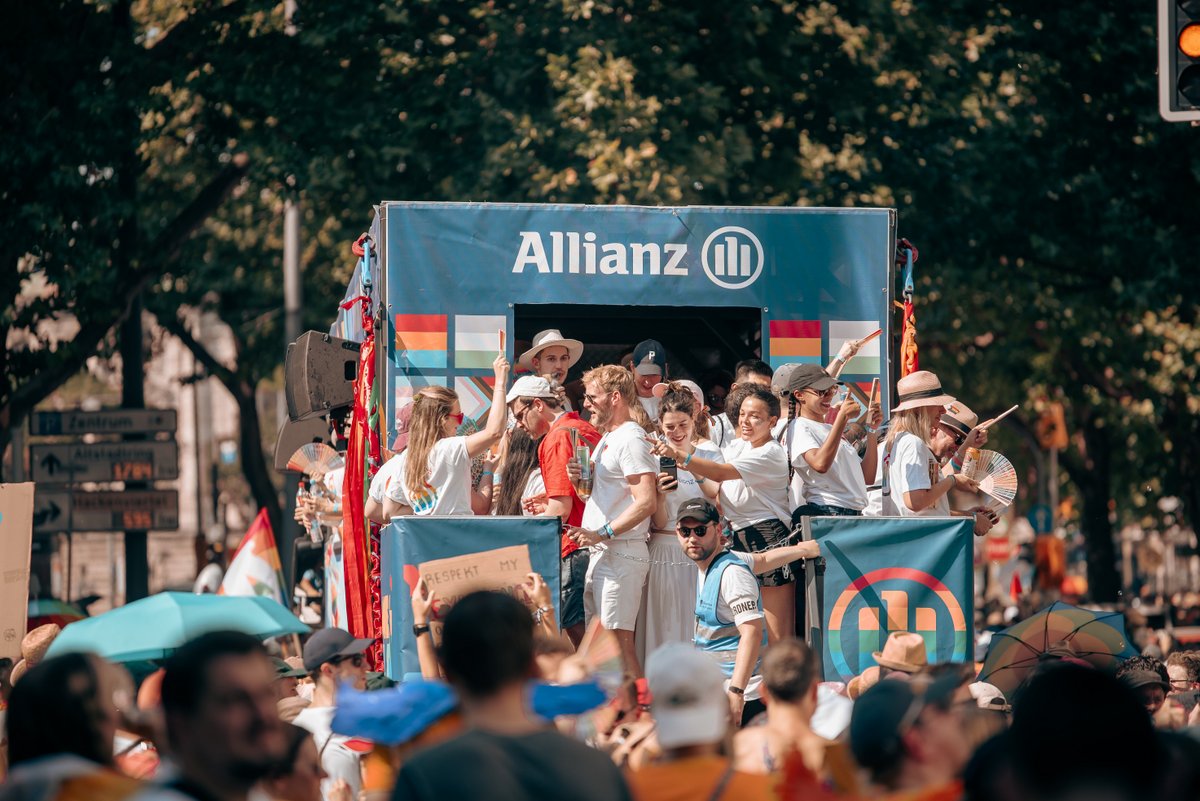 Paradewagen der Allianz mit feiernden Teilnehmenden f?rt durch die Stra?.