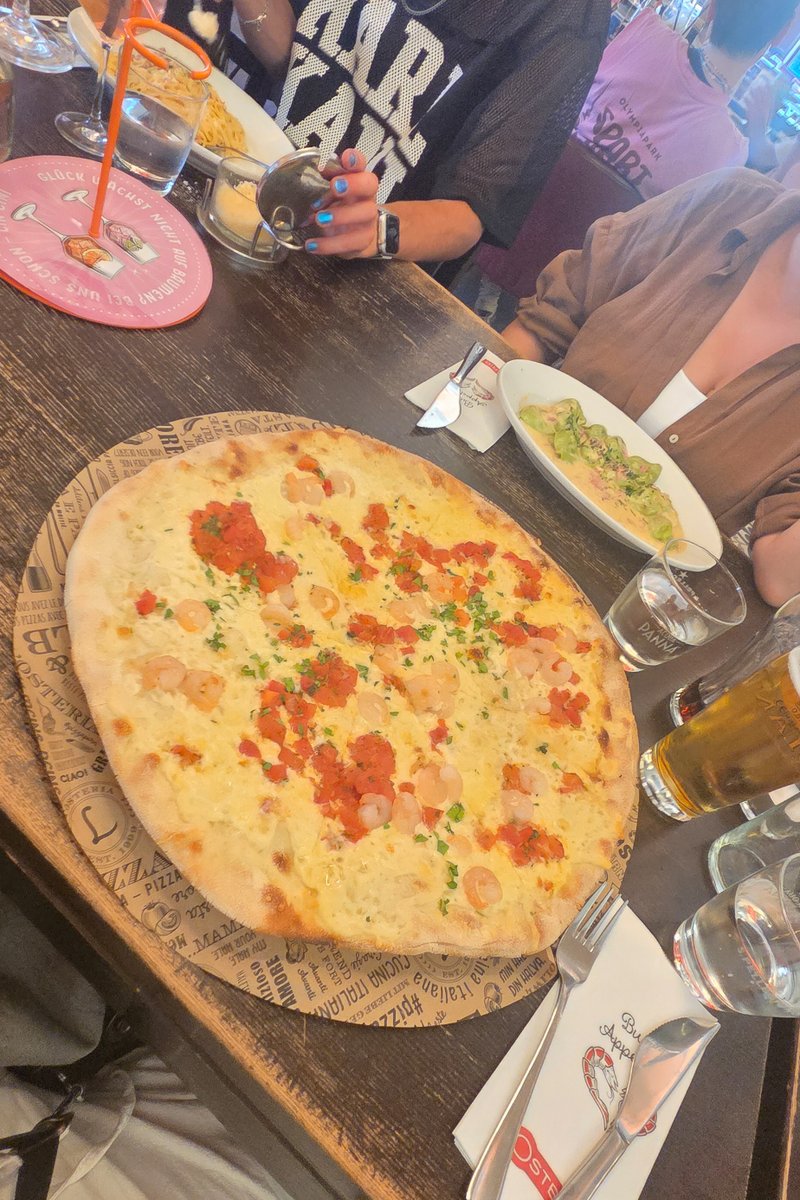 Gro? Pizza steht auf dem Tisch eines Restaurants nach dem CSD-Besuch.