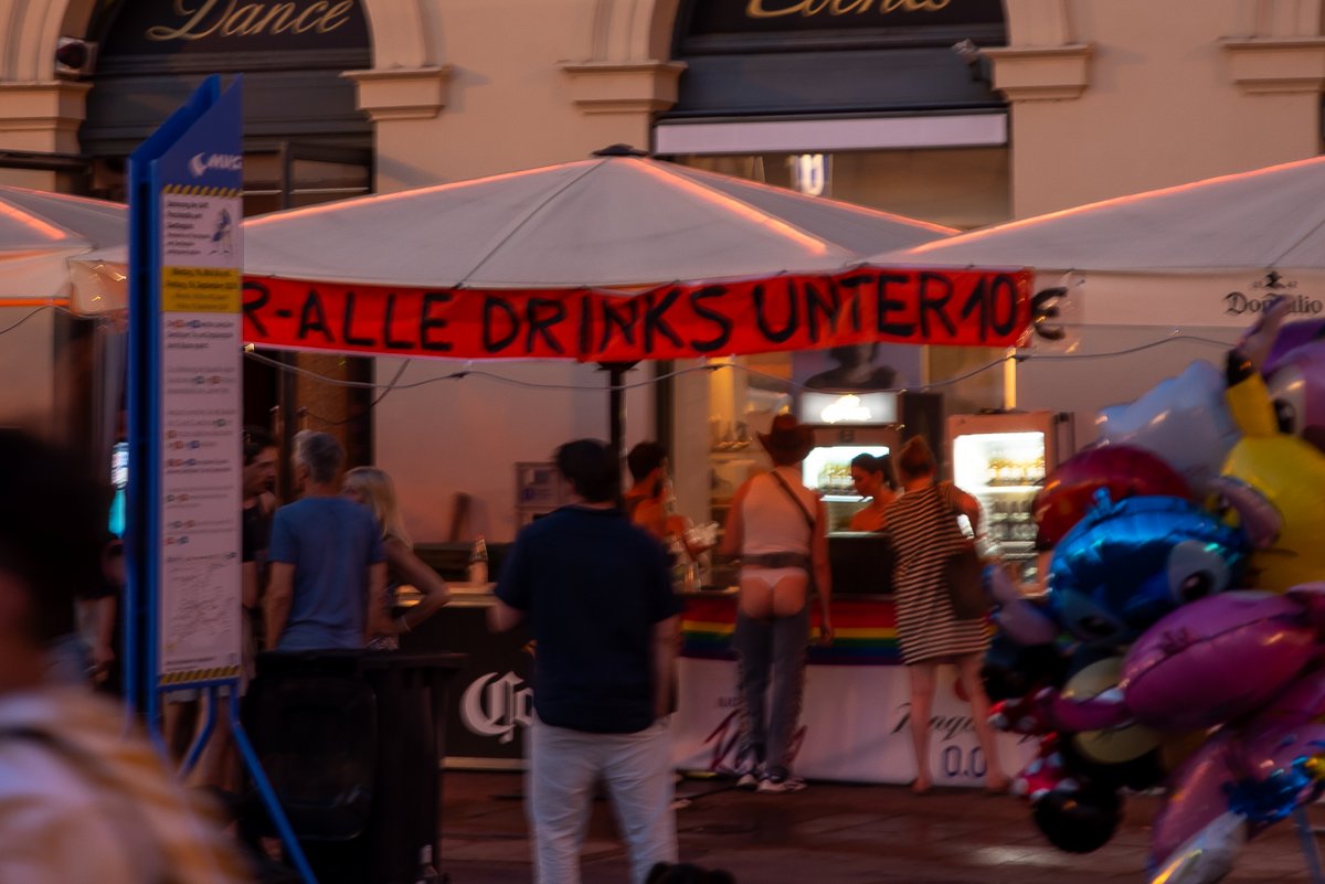 Imbissstand mit Leuchtschrift und wartenden G?ten am Abend des CSD.